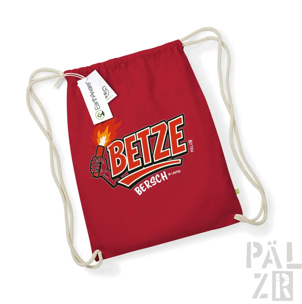 Roter Rucksack mit Kordelzug und Logo ’betze bersch’ sowie Flammen-Design, aus Baumwolle gefertigt.
