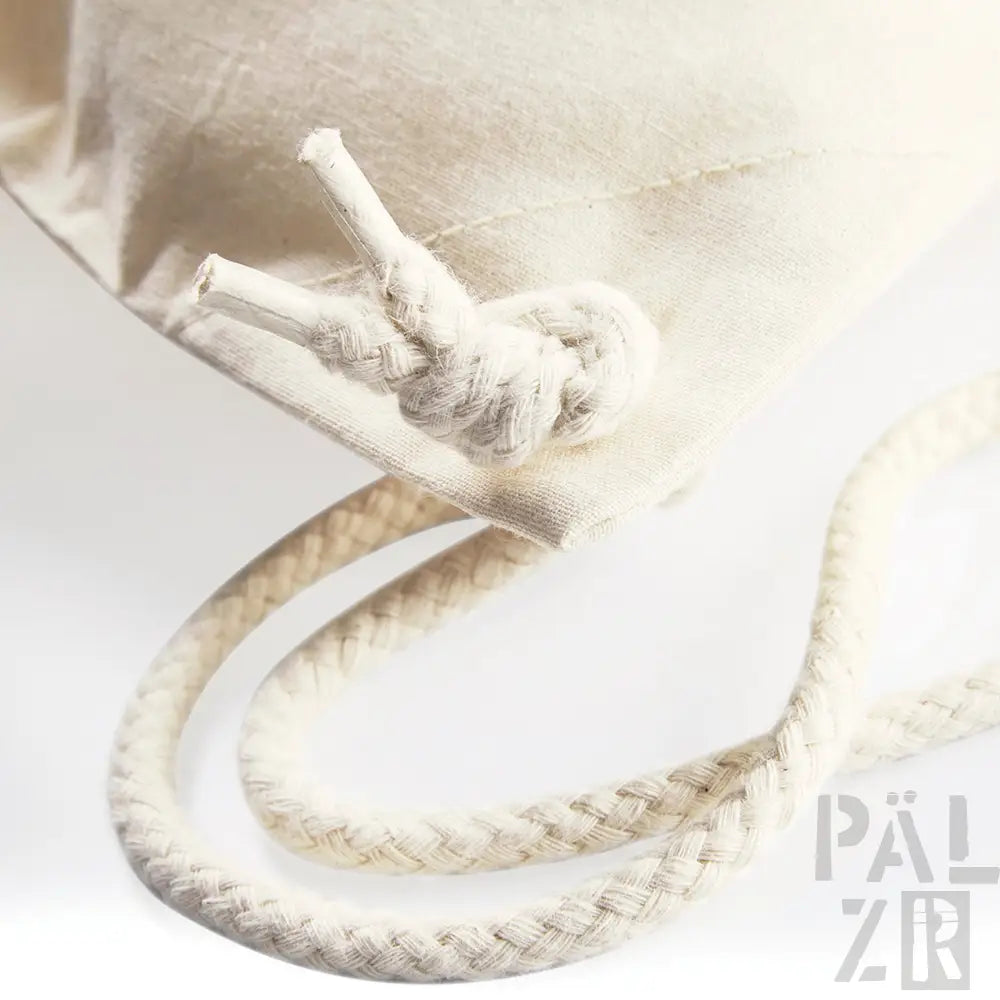 Cremefarbene Seilzugtasche mit Knotenschluss und gewebtem Muster.