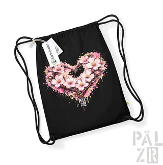 Schwarze Beutel mit Kordelzug mit einem lebendigen pinken Kirschblüten-Herz-Design mit Spritzeffekten und dem Text ’pal zib’ darunter.