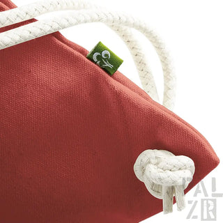 Korallen-Tragetasche mit weißen Seilgriffen und grünem Etikett.