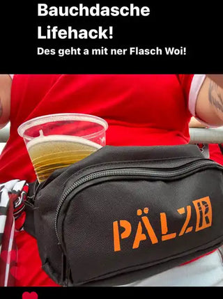 Schwarze Bauchtasche mit einem orangefarbenen »PÄLZB«-Logo und einem klaren Plastikbecher Bier in einem der Fächer.