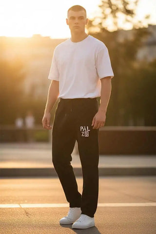 Schwarze Jogginghosen mit ’pal zileri’-Logo am Bein, weißes T-Shirt und weiße Sneakers.