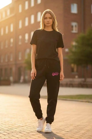 Schwarze Nike-Jogger-Hosen mit pinkem Logo und weißen Sneakers.