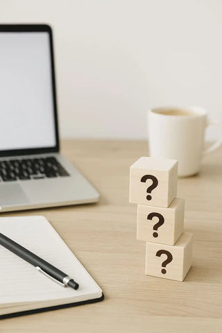 Ein Stapel aus drei hell-colored Holzklötzen, von denen jeder ein Fragezeichen trägt.