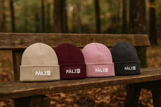 Vier weiche, gefaltete Mützen in Beige, Burgund, Rosa und Schwarz.