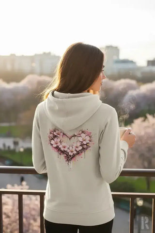 Eine weiche, off-white Hoodie mit einem lebendigen, pinken Kirschblüten-Herz-Design auf dem Rücken.